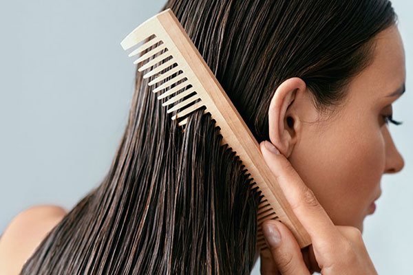 Woman running a comb through wet hair