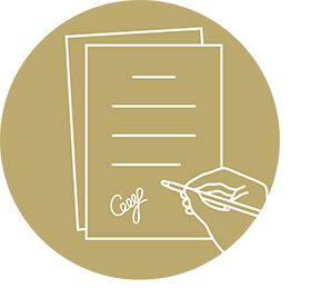 Hand holding a pen signing papers